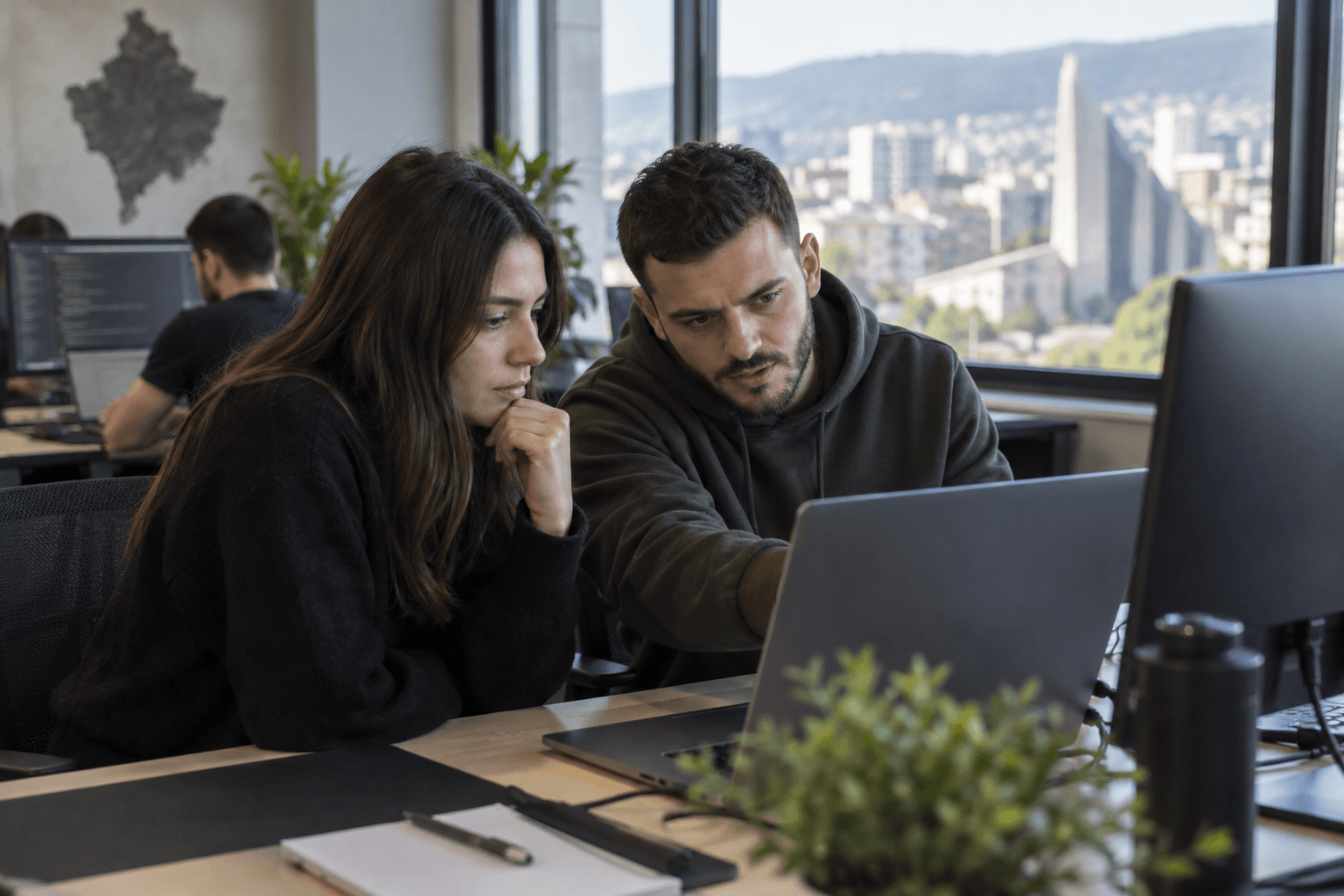 A software team reviewing a screen together in a Prishtina office